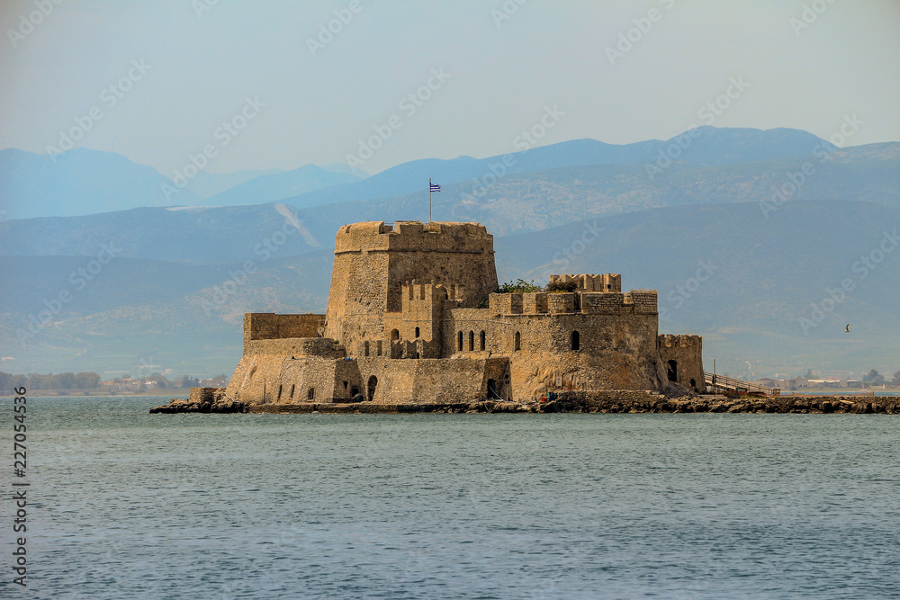 Historic Bourtzi Castle, located near the Nafplio Port (Nauplion), Greece, with a bacground of mountains.