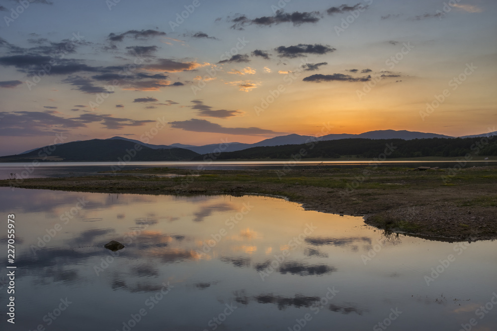 Colorful, spectacular sunset over Balkan mountain and artificial lake Jrebchevo. Last rays of light. Landscape, background.