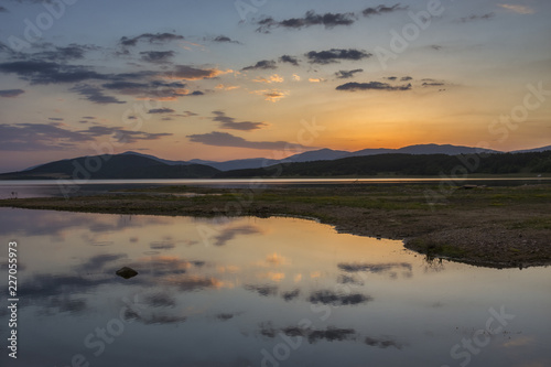 Colorful  spectacular sunset over Balkan mountain and artificial lake Jrebchevo. Last rays of light. Landscape  background.
