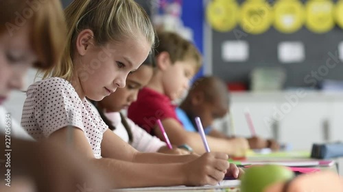 Student girl writing on textbook during exam