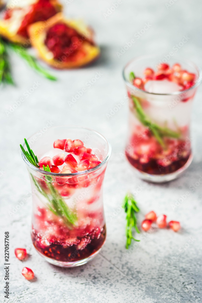 Rosemary pomegranate infused water with ice cubes. Selective focus, space for text. Rosemary pomegranate infused water with ice cubes. Selective focus, space for text.