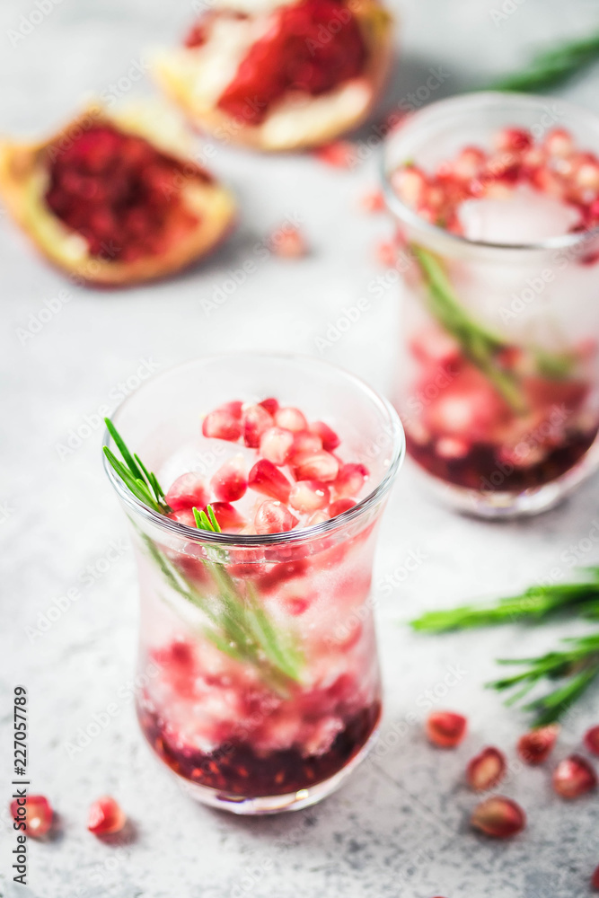 Rosemary pomegranate infused water with ice cubes. Selective focus, space for text. Rosemary pomegranate infused water with ice cubes. Selective focus, space for text.