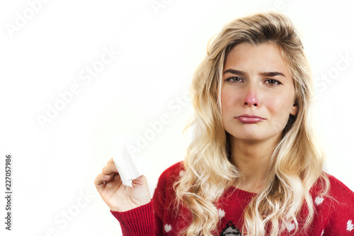 Symptoms of flu or allergies. Strong young European woman with fever, sneezing in a tissue, allergy, cold, with copy space, young girl, portrait of a sick woman, isolated on a white background.