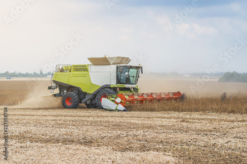 Agricultural combine harvests soybeans in the field