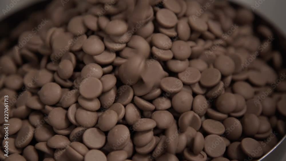 Pouring chocolate into bowl for tempering. Technology of production of sweets in factory Pouring chocolate into bowl for tempering. Technology of production of sweets in factory
