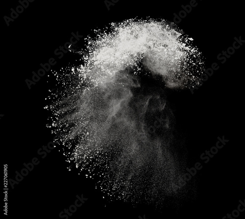 White powder or flour explosion isolated on black background  freeze stop motion object design photo