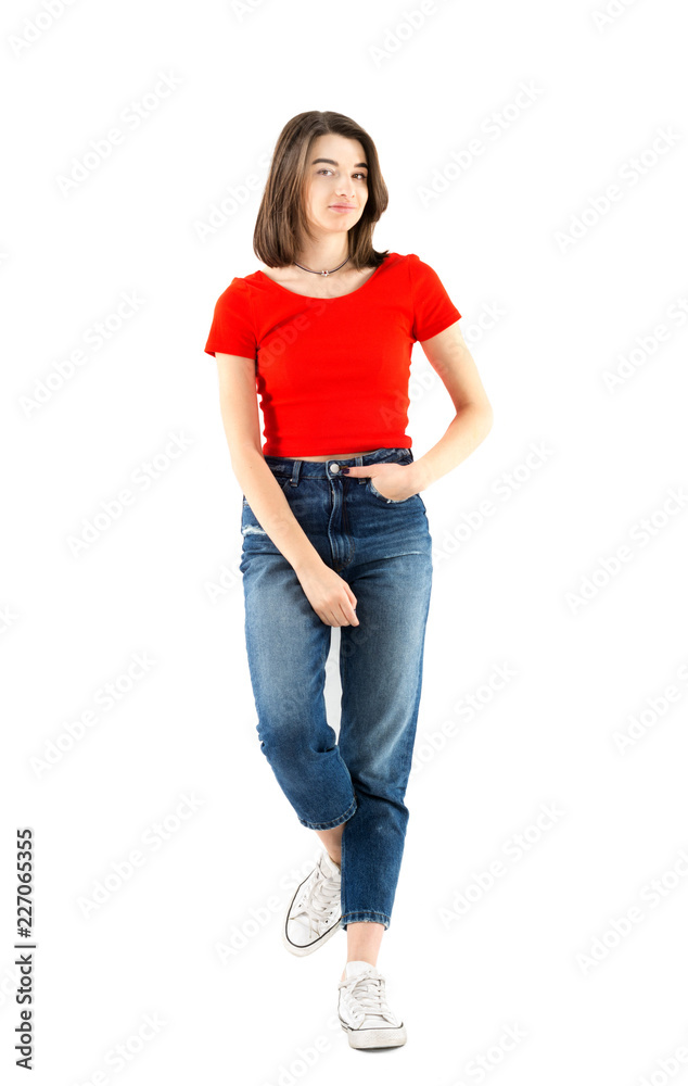Full-length portrait of a beautiful young girl wearing red t-shirt and jeans  leaning on a wall on white background, studio shoot Stock Photo | Adobe  Stock