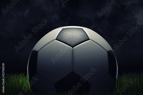3d rendering of a single football ball standing on a grass field on a dark background. © gearstd