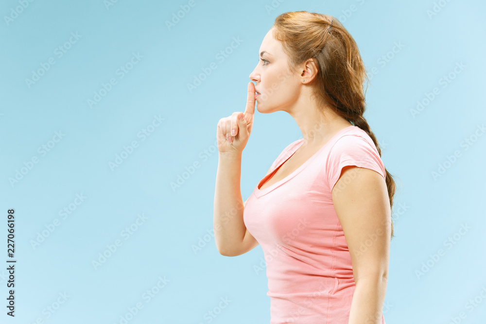 Secret, gossip concept. Young woman whispering a secret behind her hand. Business woman isolated on trendy blue studio background. Young emotional woman. Human emotions, facial expression concept. Secret, gossip concept. Young woman whispering a secret behind her hand. Business woman isolated on trendy blue studio background. Young emotional woman. Human emotions, facial expression concept.