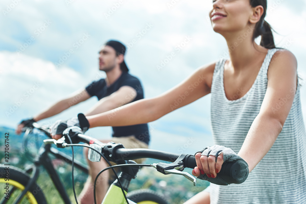 Fototapeta premium A man and a woman are laughing and cycling. Close up view