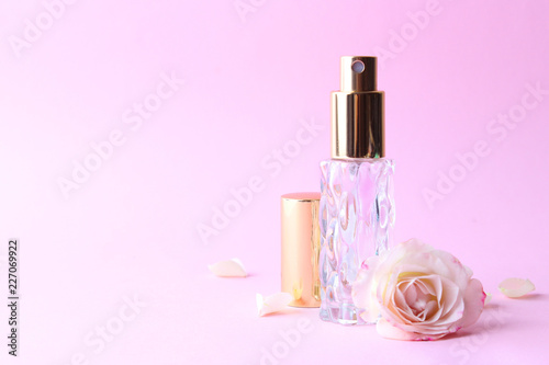 perfume and flowers on a colored background.