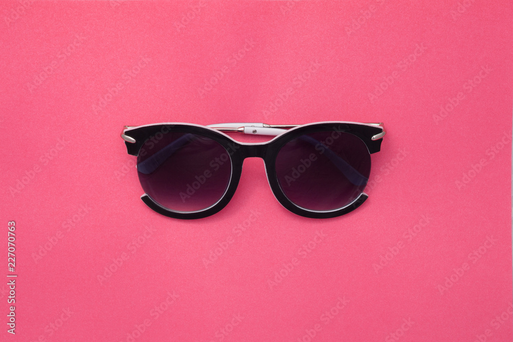 Sunglasses for women on a pink background. Square summer texture. Sunglasses for women on a pink background. Square summer texture.