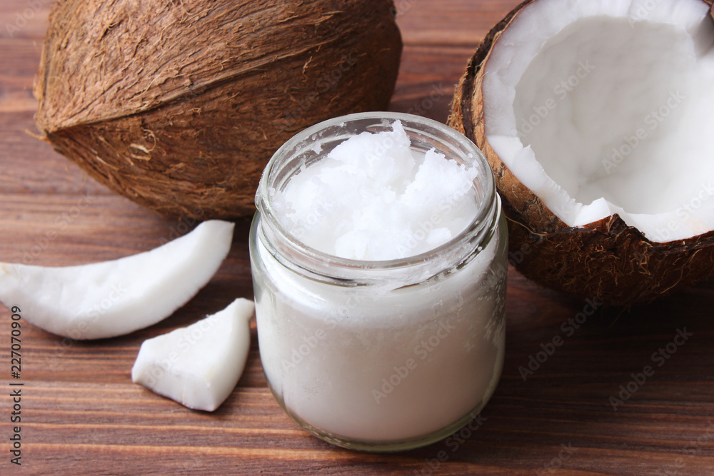 coconuts and coconut oil on a wooden background. coconuts and coconut oil on a wooden background.