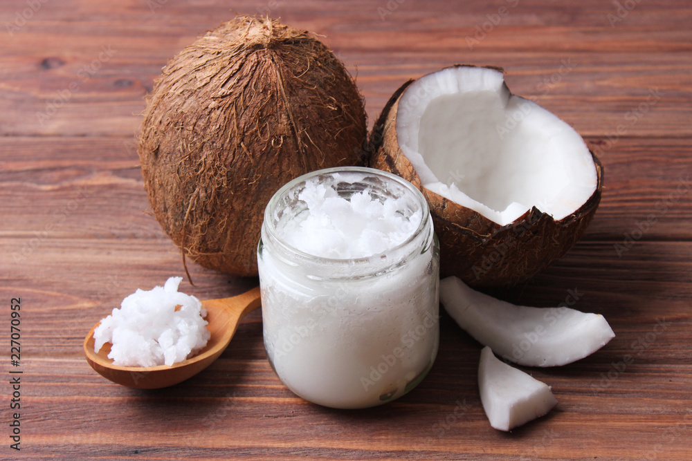 coconuts and coconut oil on a wooden background. coconuts and coconut oil on a wooden background.
