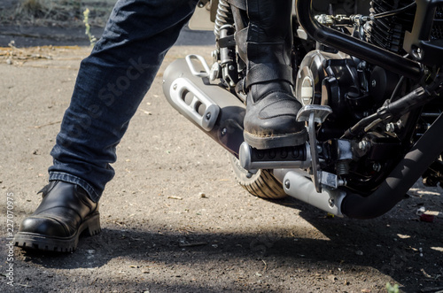 foot bikers in motorcycle boots sitting on a motorcycle