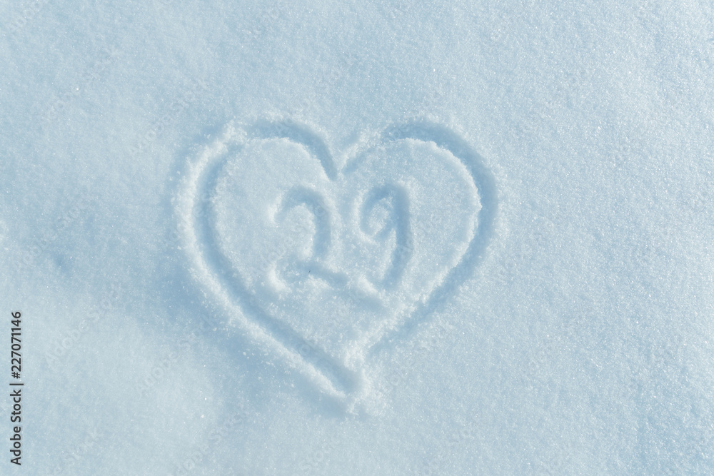 A figure of twenty nine written in the snow in the painted heart. Snow texture. A figure of twenty nine written in the snow in the painted heart. Snow texture.