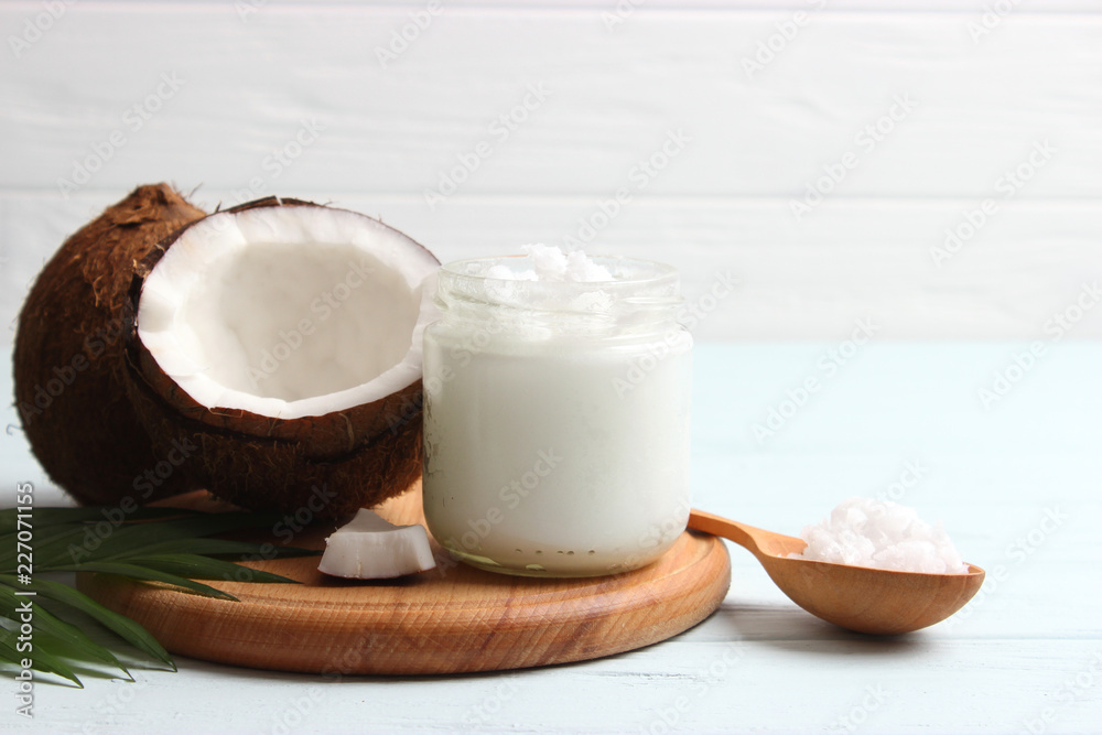 coconuts and coconut oil with tropical leaves on a wooden background coconuts and coconut oil with tropical leaves on a wooden background
