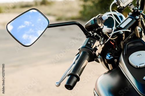 reflection of the nab and clouds in the motorcycle mirror, motorcycle steering wheel and motorcycle fuel tank