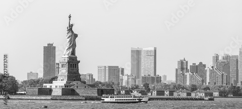 Statue of Liberty with Liberty State Park and Jersey City skyscrapers in background, USA. Black and white image.