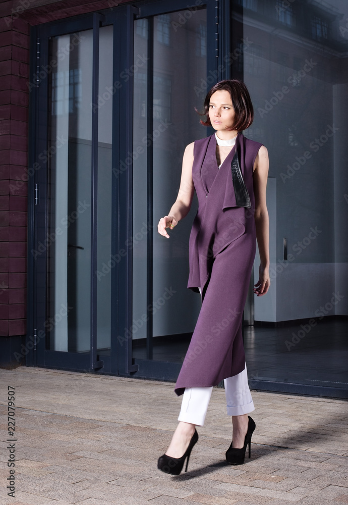 Street fashion portrait of a beautiful young woman in purple dress Street fashion portrait of a beautiful young woman in purple dress