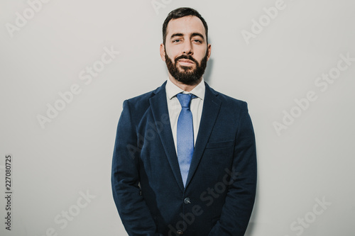 Young businessman, dressed in suit and tie placed on a neutral background. Different facial gestures, expressing emotions. Lifestyle.