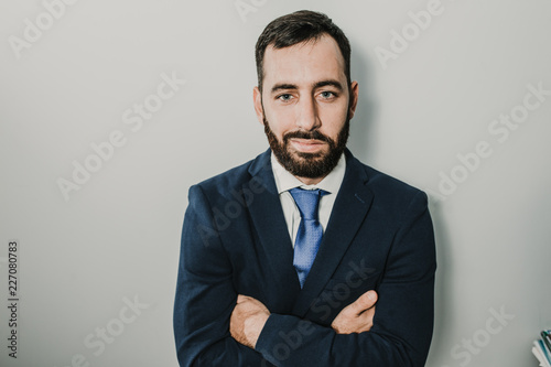 Young businessman, dressed in suit and tie placed on a neutral background. Different facial gestures, expressing emotions. Lifestyle.
