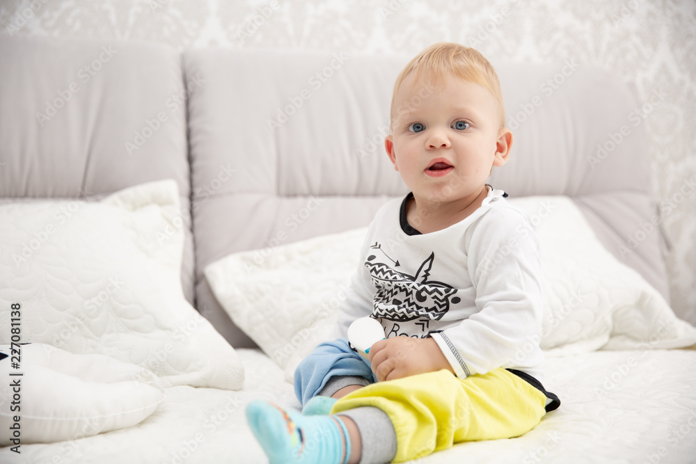 Playful little boy wearing blue pyjamas in bed Playful little boy wearing blue pyjamas in bed