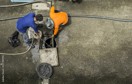 Картината върху платно Pipe cleaning drainpipe by two workers to get rid of obstruction Passage of water in the rainy season in image bird eye view