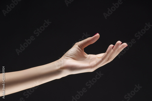 Closeup of beautiful woman hand with red manicure on the nails. Cream for palms, manicure and beauty treatment. Elegant and graceful arm with slender graceful fingers