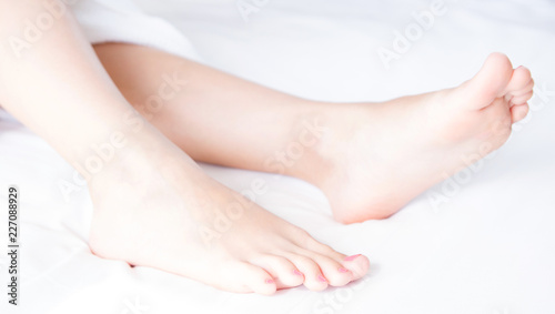 Perfect clean female feet .Beautiful and elegant woman's, girl foot .Spa ,scrub and foot care concept.Light room, clean bedding