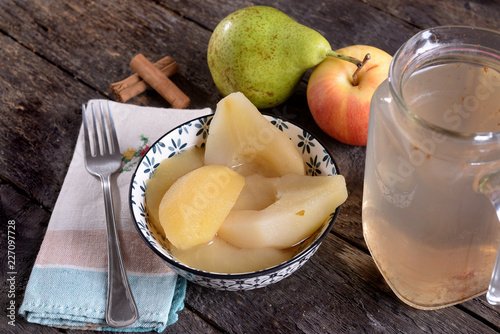 Bowl with cooked apples and pears and jug of syrup  photo