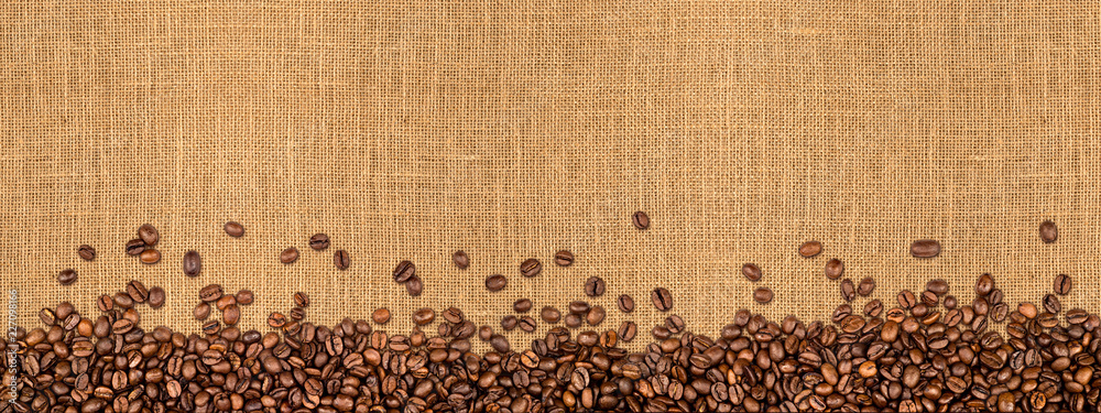 Naklejka premium Kawowy jutowy tło Kawowe fasole na naturalnej włóknie teksturze / kawowe fasole na naturalnym burlap tekstury tle