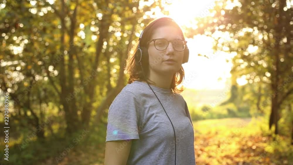 ragazza ascolta musica con le cuffie in un bosco ragazza ascolta musica con le cuffie in un bosco