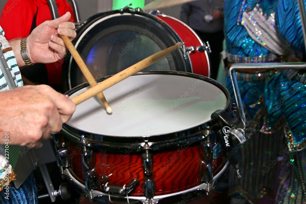 Obraz premium The drummer is hitting the drum with his sticks.