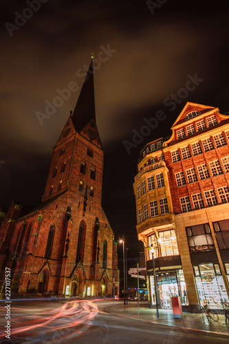 City view of Hamburg downtown at night. View of St. Petri church and traditional red brick buildings. Long exposure. Car light trails. Hamburg, Germany