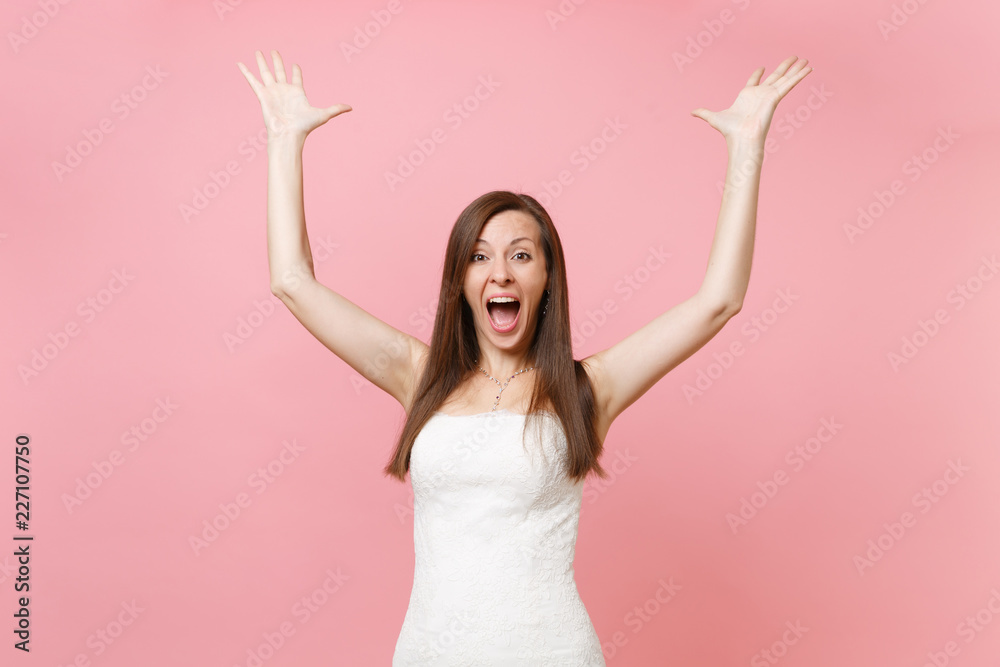 Portrait of overjoyed happy attractive bride woman in lace white wedding dress standing spreading hands isolated on pastel pink background. Wedding celebration concept. Copy space for advertisement. Portrait of overjoyed happy attractive bride woman in lace white wedding dress standing spreading hands isolated on pastel pink background. Wedding celebration concept. Copy space for advertisement.