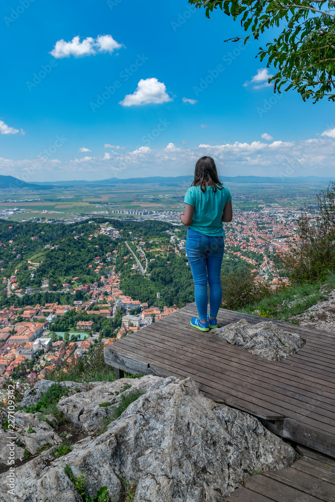 Girl admiring the overview of Brasov city from Tampa mountain in Brasov, Romania