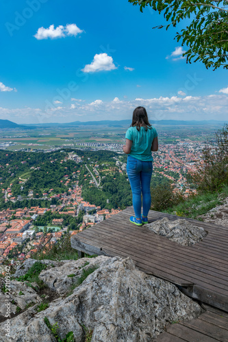 Girl admiring the overview of Brasov city from Tampa mountain in Brasov, Romania