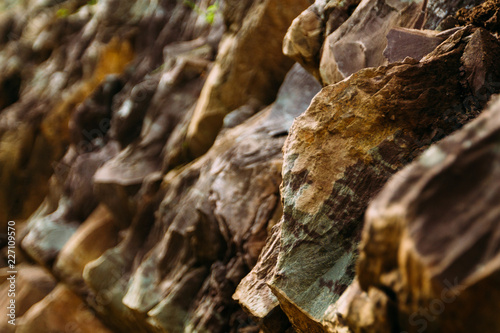 Sharp mountain rocks by the river. Many layers of stone