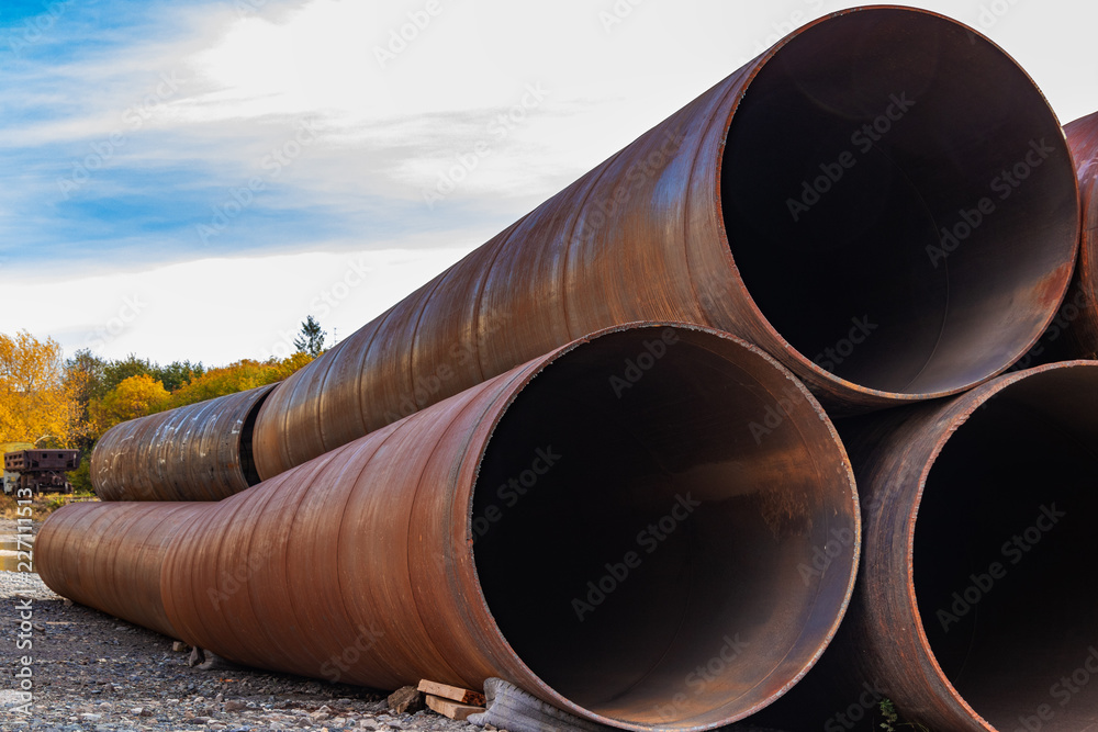 Large rusty metal pipes under the open sky. Industrial landscape. Large rusty metal pipes under the open sky. Industrial landscape.