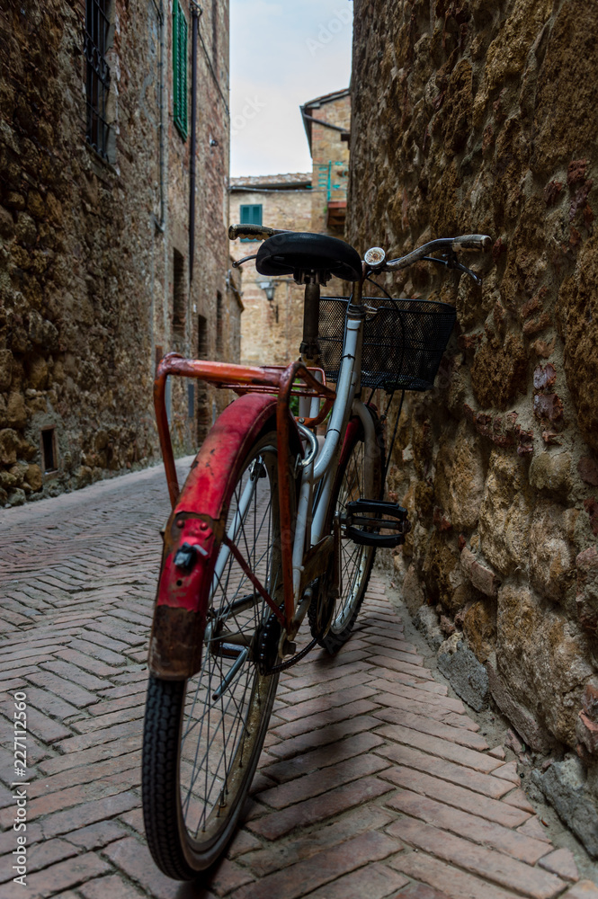 Red old bicycle in a little alley of a medieval village