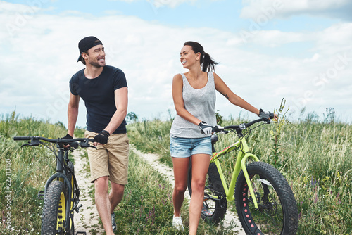 Young couple resting after bike ride in field