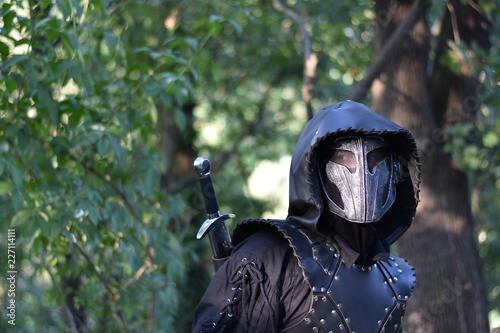 Man in fantasy leather armor and mask, original bounty hunter character
