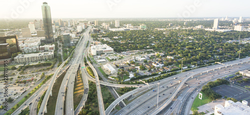 Panorama aerial Interstate I-610 freeway massive intersection and Houston midtown skylines background. Stack interchange, elevated road junction overpass viaduct. Nightly degree view metropolitan area