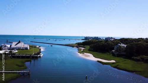 The camera flies across the marina revealing many docked vessels and boats. You can see the channel marker buoys in the water. Boats make there way in and out. photo