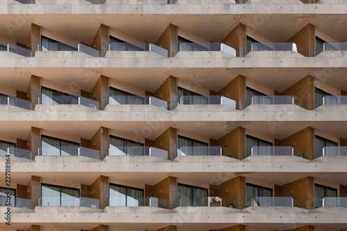 full frame shot of repeating pattern with windows and balcony on a bulding front of a retro vintage hotel