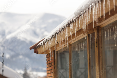 Winter icicles hanging from eaves of roof © dturphoto