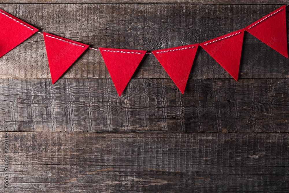 Red triangle flags hanging over wooden background Red triangle flags hanging over wooden background