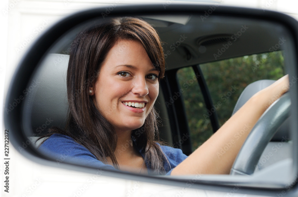 Young Woman Driver Reflected In The Car Mirror