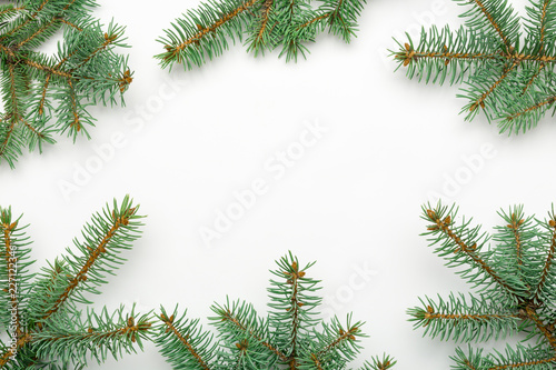 Holiday frame of Christmas decorations on white background with fir branch, gold and red balls, stars. Elegant New Year`s snowy card. Top view. Flat lay.